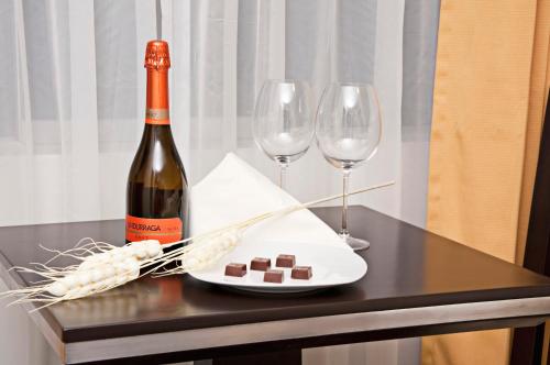 una botella de vino y dos copas de vino en una mesa en Flamante Hotel & Suite, en Lima