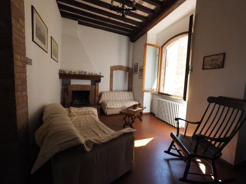 een woonkamer met een bank en een stoel bij Antica Posta in San Gimignano