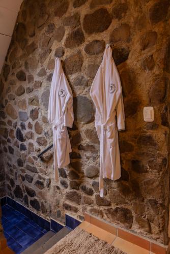 two white robes hanging on a stone wall at La Dama de los vientos in Cerro Azul