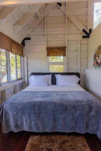 a bedroom with a large bed in a room with windows at La Dama de los vientos in Cerro Azul