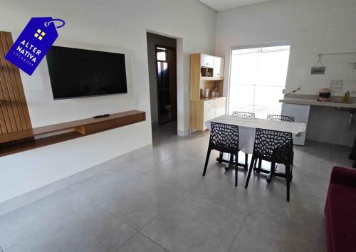 a kitchen and dining room with a table and chairs at Casa Indaiá in Primavera do Leste
