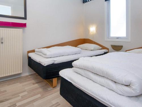 two beds in a room with white sheets at 6 person holiday home in Glesborg in Glesborg