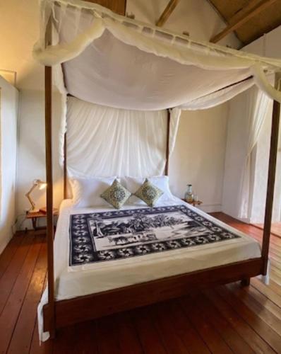 a bedroom with a bed with a canopy at Lambawany in Sainte Marie