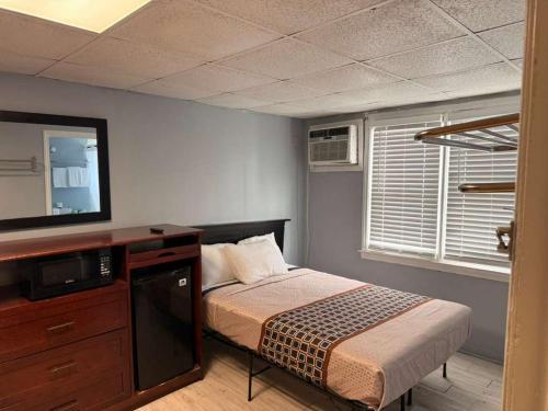 a bedroom with a bed and a television in a room at Hammock Inn & Suites North Beach Hotel in Seaside Heights