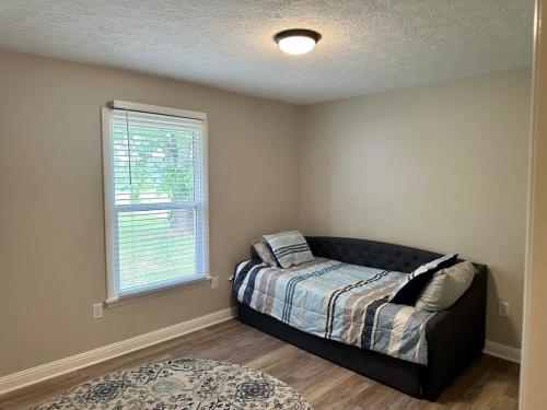 a bedroom with a bed and a window and a couch at Twin Oaks Haven in Murfreesboro