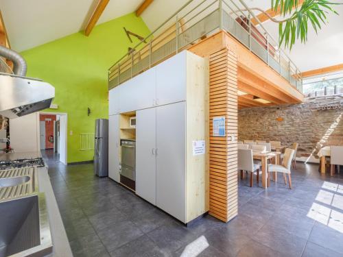 a kitchen with white cabinets and a green wall at Moderscheid Cottage with Spa in Amblève