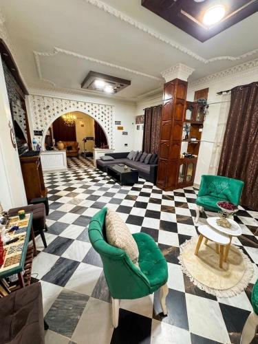 a living room with a green chair and a checkered floor at Maison moderne & cosy in Constantine