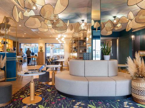 a lobby with a circular seating area in a restaurant at IBIS Budget Pontivy in Pontivy