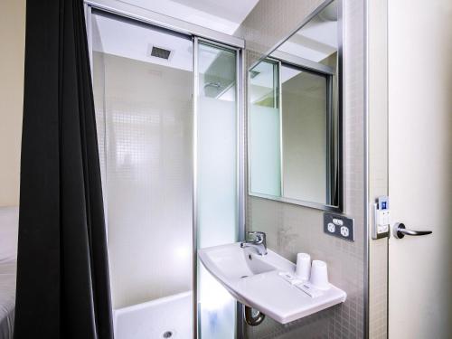 a bathroom with a sink and a shower at ibis Budget Sydney Olympic Park in Sydney