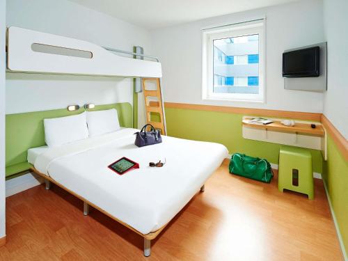 a bedroom with a large white bed and a bunk bed at ibis budget Chateaudun in Châteaudun