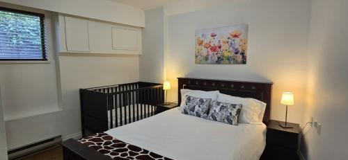 a bedroom with a bed and a painting on the wall at Bright 2 BR, Great Location in West Vancouver