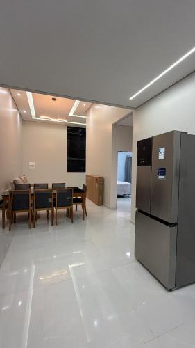 a kitchen and dining room with a table and a refrigerator at Casa moderna próximo ao bumbodromo in Parintins