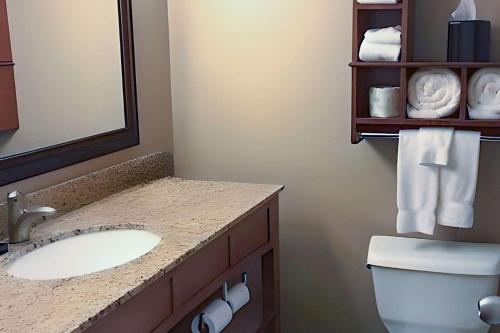 a bathroom with a sink and a toilet and a mirror at Quality Inn & Suites Stillwater in Stillwater