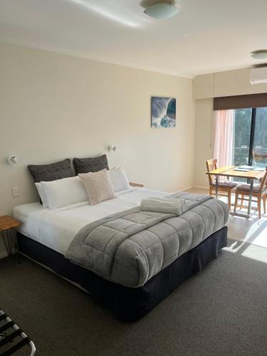 a bedroom with a large bed with a table and chairs at Beach Studio with Ocean View in Gnarabup