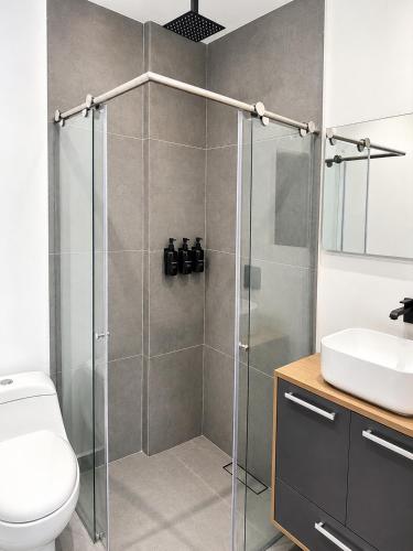 a bathroom with a shower and a toilet and a sink at Hotel Laureles Loft in Medellín