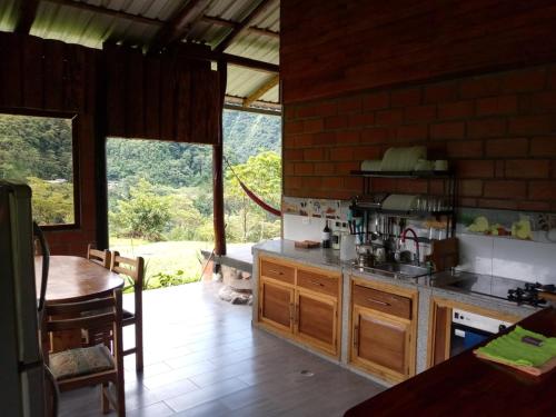 a kitchen with a counter and a table and some windows at Rancho San Andrés in Palora
