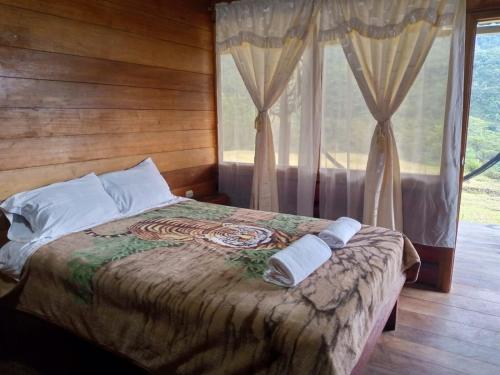 a bedroom with a bed with two towels on it at Rancho San Andrés in Palora
