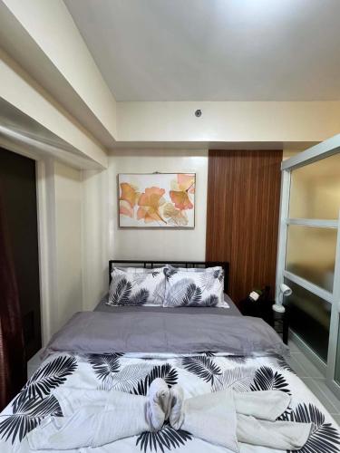 a bedroom with a large bed with white sheets at Maldee's Place Tagaytay Prime Residences in Tagaytay