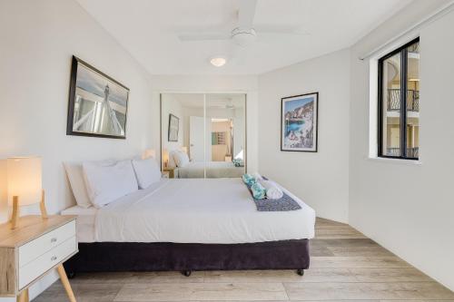 a bedroom with a large white bed and a desk at Nautilus Resort - Private Apartment in Mooloolaba