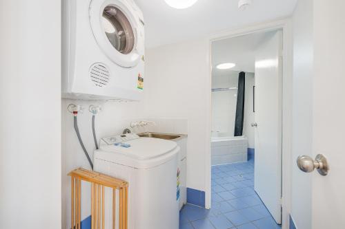 a bathroom with a sink and a washing machine at Nautilus Resort - Private Apartment in Mooloolaba