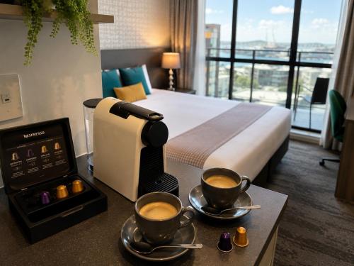 a hotel room with two cups of coffee on a counter at Quest on Eden Auckland CBD Apartment Hotel in Auckland