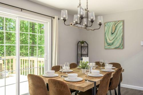 a dining room with a wooden table and chairs at Tucked in the Woods - Jacuzzi Firepit Pooltable in Long Pond