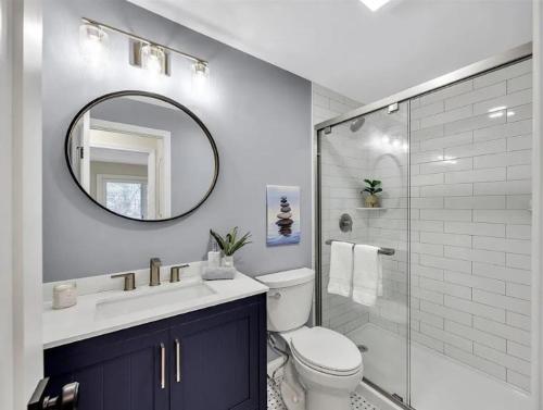 a bathroom with a toilet and a sink and a mirror at New Cape Cod Condo Near Beaches in Brewster