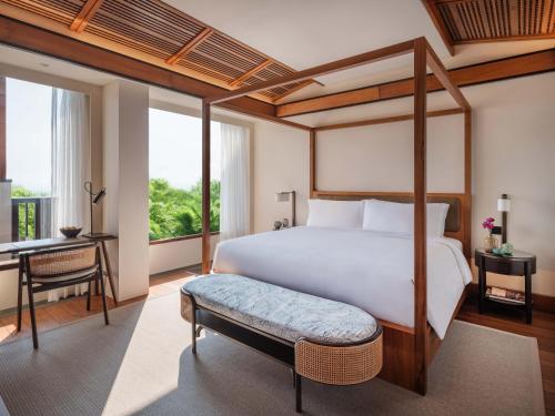 a bedroom with a bed and a desk and a bed and a bedskirts at Regent Bali Canggu in Canggu