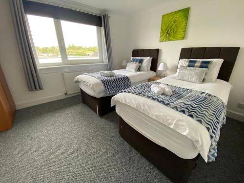 a bedroom with two beds and a window at Pure Home Oakley Central TBA in Dunfermline