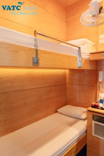 a small bed in a room with wooden walls at VATC Sleep Pod Terminal 1 in Noi Bai