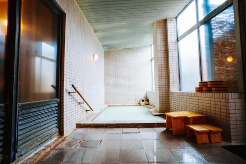a bathroom with a bath tub and a window at ZAO SPA HOTEL Kiraku in Zaō Onsen