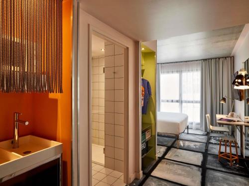 a bathroom with a shower and a sink and a toilet at Mama Shelter Lyon in Lyon
