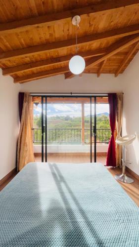 a bedroom with a bed and a large window at Apartamento La bonita guatape in Guatapé