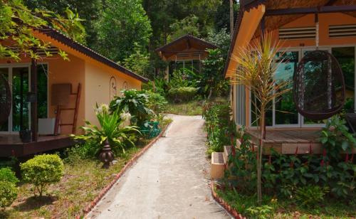 a walkway leading to a house with plants at Samloem Laguna Resort in Koh Rong Sanloem