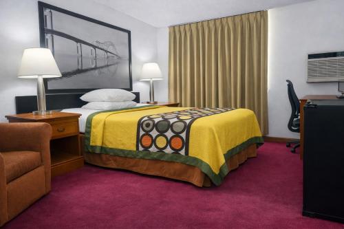 a hotel room with a bed and a chair at Algona Inn in Algona