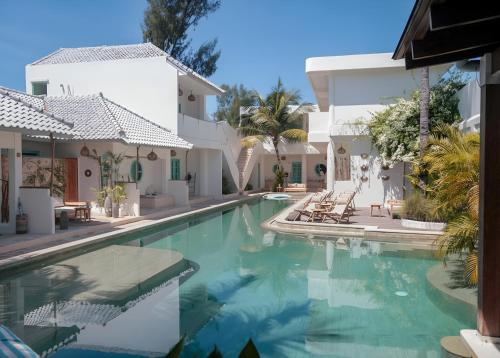 a swimming pool in front of a house at Quma Boutique Hotel - Adults Only in Gili Trawangan
