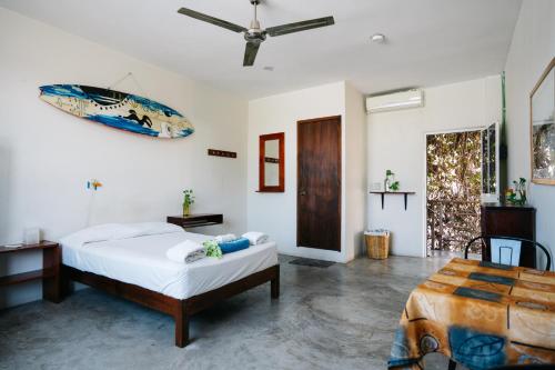 a white bedroom with a bed and a table at Puerto Dreams H in Puerto Escondido