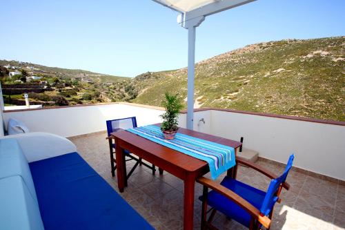 Thea House Patmos في Kámbos: طاولة وكراسي على شرفة مطلة