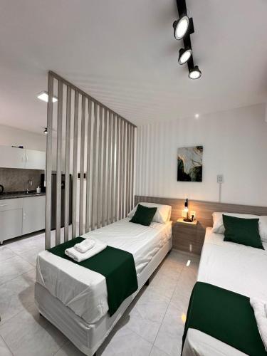a bedroom with two beds and a kitchen at Vela Villa Apart N3 in Villa Ángela