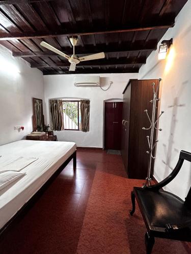 a large bedroom with a large bed and a chair at Remasailam Homestay - Thiruvananthapuram , Calm & Blend with Nature in Trivandrum