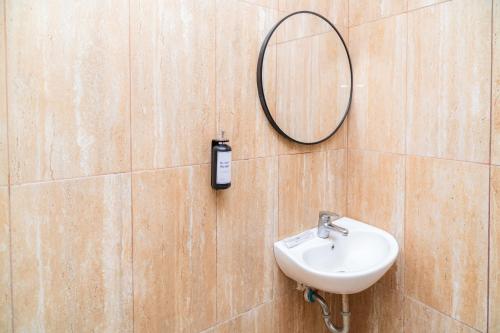 a bathroom with a mirror and a sink at SANS Hotel Bobo Home Jambi in Jambi