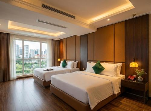 a hotel room with two beds and a window at Bon Ami Hotel - Thiên Xuân in Ho Chi Minh City