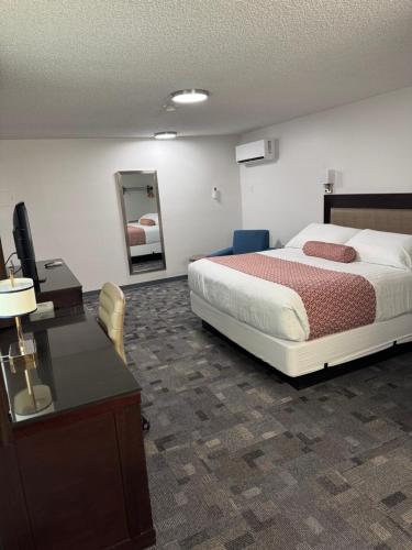 a bedroom with a bed and a desk and a mirror at Gateway Inn in Lyman