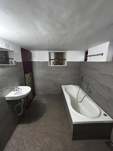 a bathroom with a bath tub and a sink at Remasailam Homestay - Thiruvananthapuram , Calm & Blend with Nature in Trivandrum