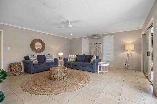 a living room with two blue couches and a table at Noosa Sunrise - Pet-friendly with Pool in Sunrise Beach