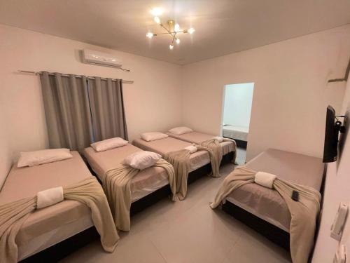 a room with four beds in a room at Pousada Recanto do Oásis in Triunfo
