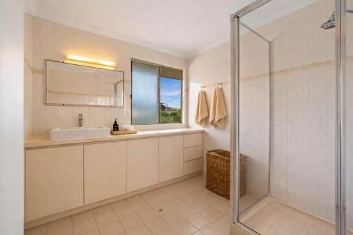 a bathroom with a sink and a glass shower at Grandview Holiday Beach House in Gracetown