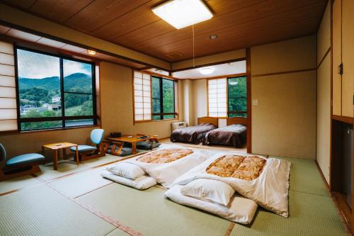 a room with two beds and windows in a room at ZAO SPA HOTEL Kiraku in Zaō Onsen