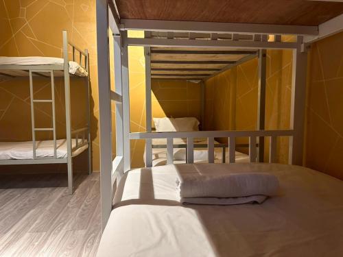 two bunk beds in a room with yellow walls at The Breeze Hostel in Haad Rin
