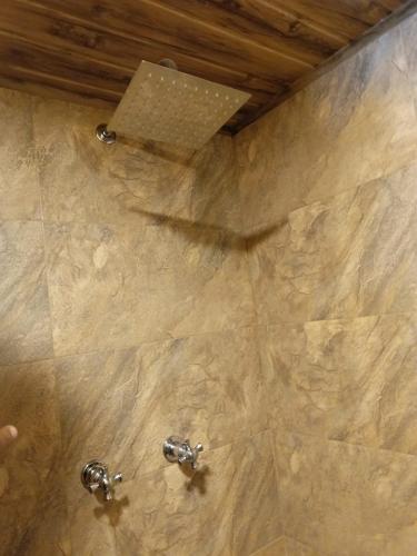 a shower with two faucets in a bathroom at Hotel Antonela Amorim in Barrio Centenario